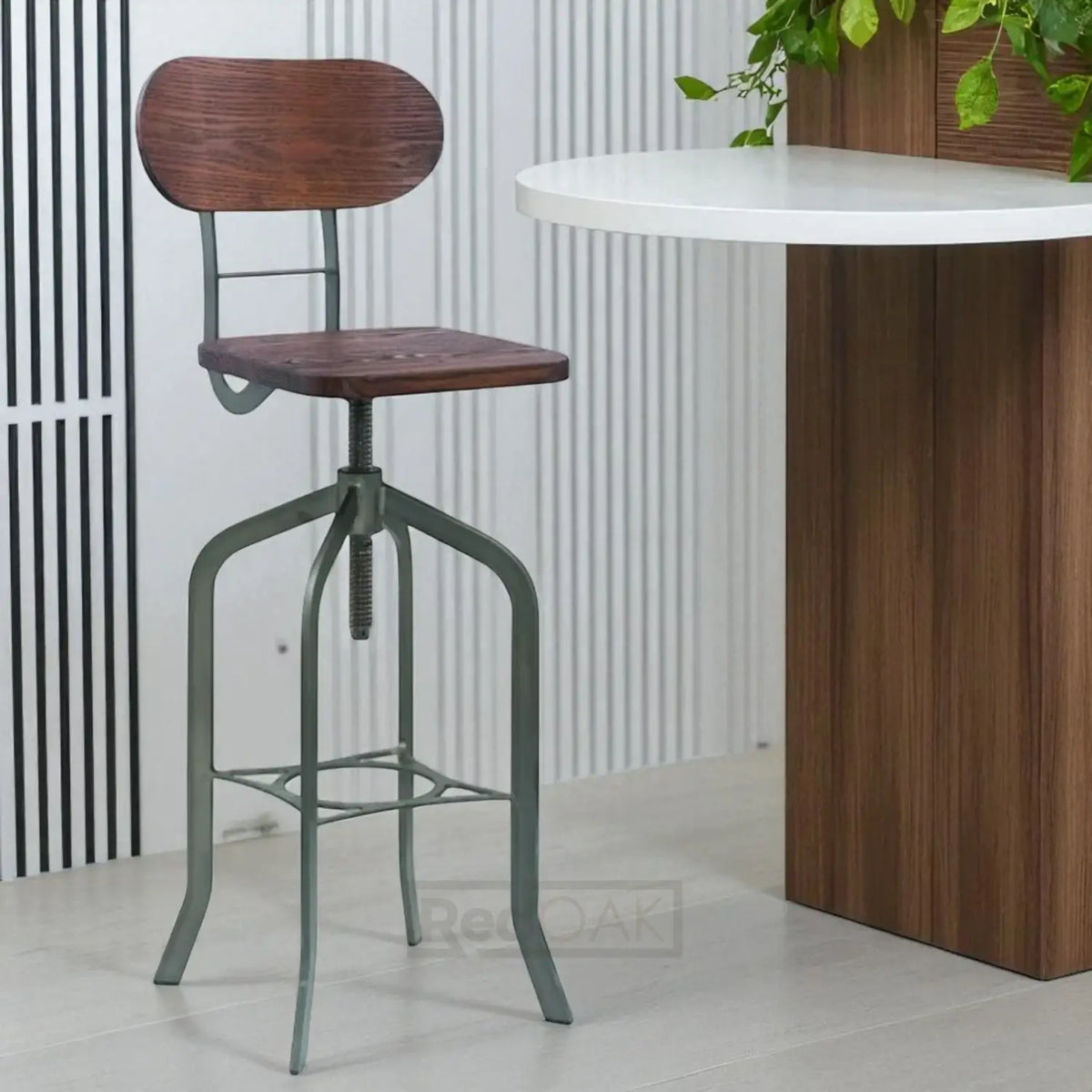 Wooden bar stool with metal legs next to a wooden table.