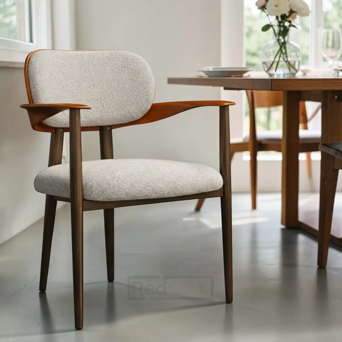 Dining chair with wooden frame and gray cushion in a bright room.
