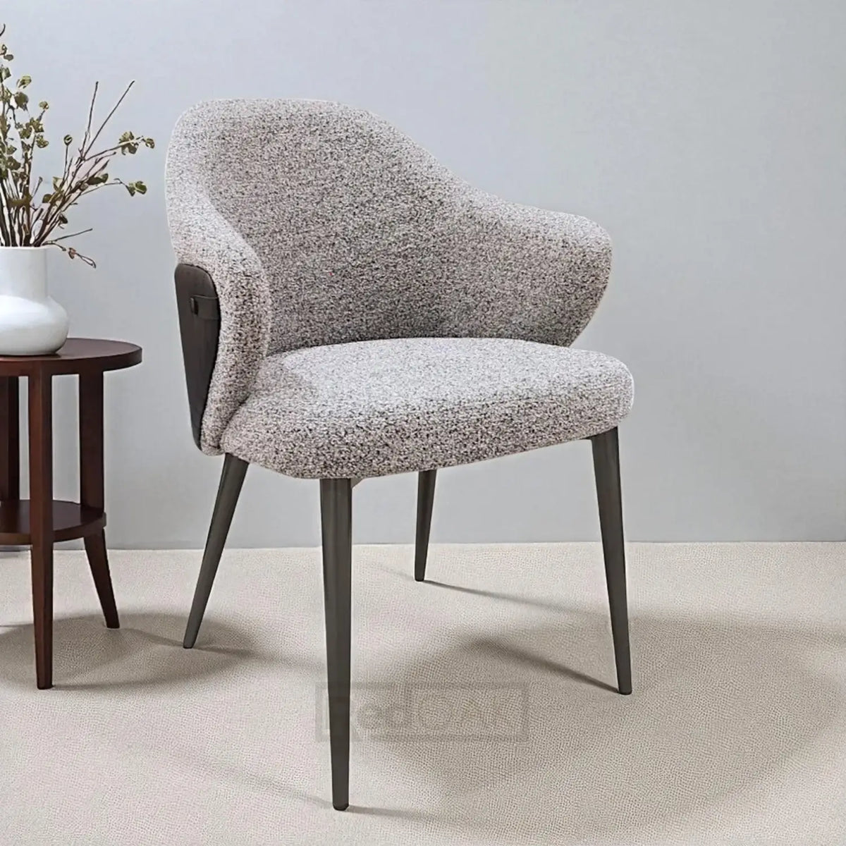 Gray textured chair with wooden legs in a minimalistic room.