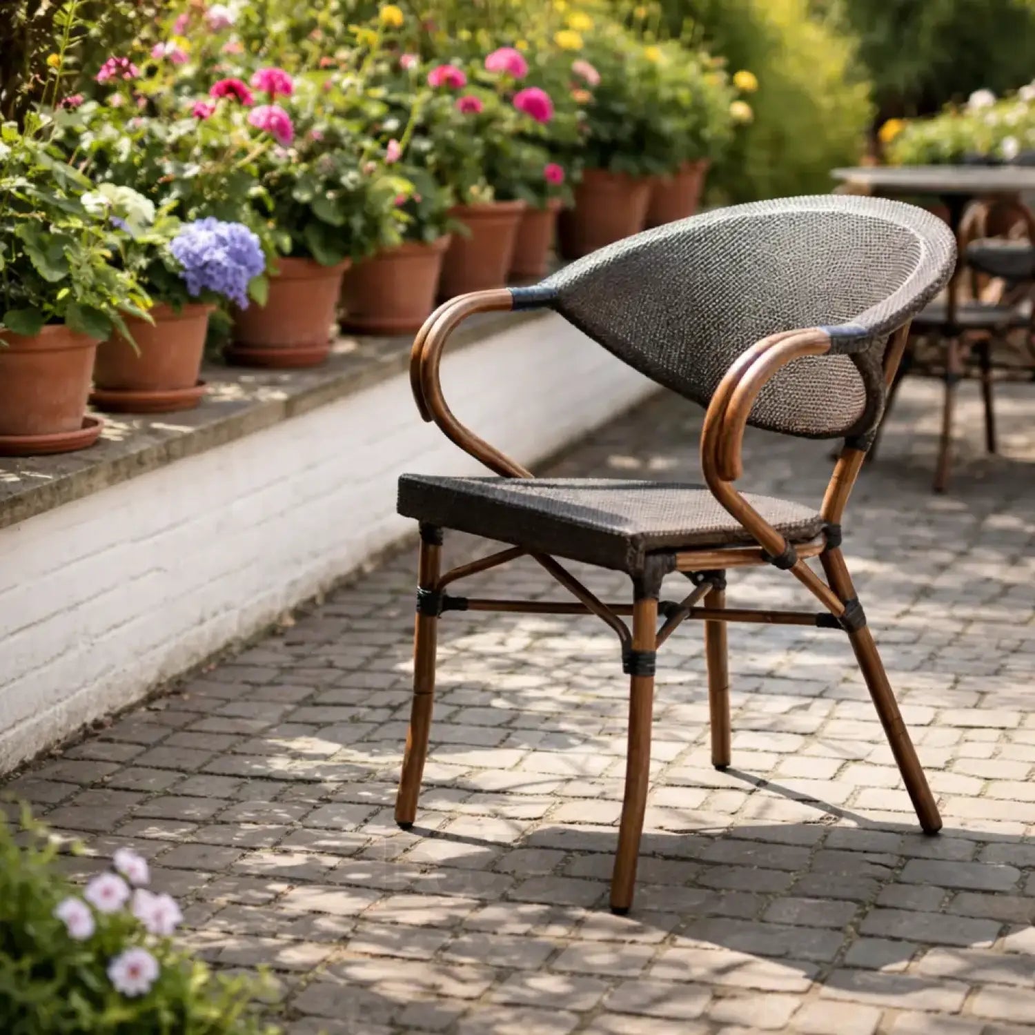 Wicker chair on a patio with potted plants in the background