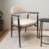 Beige leatherette dining armchair with metal frame in a room setting