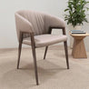 Beige armchair with wooden legs in a room setting with a plant and small table.