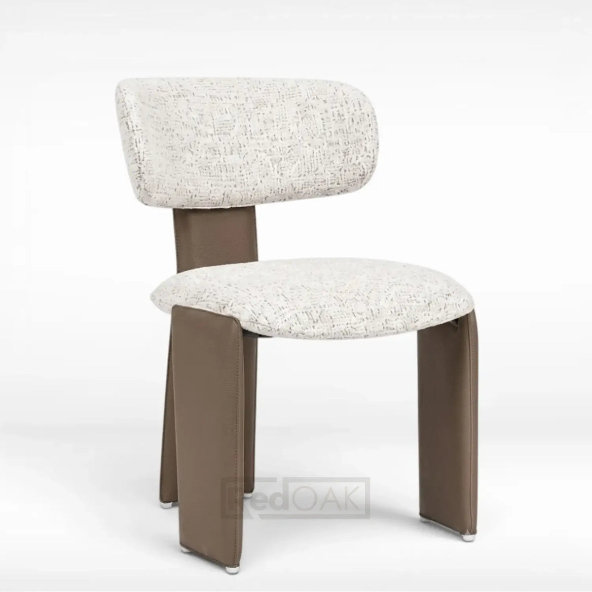 A modern accent chair featuring a textured cream bouclé upholstered seat and backrest, supported by sculptural, tapered brown legs with small silver metal feet, shown on a white studio background.
