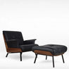 Black leather armchair with matching ottoman on a white background