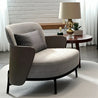 Gray armchair with a patterned pillow in a living room setting.