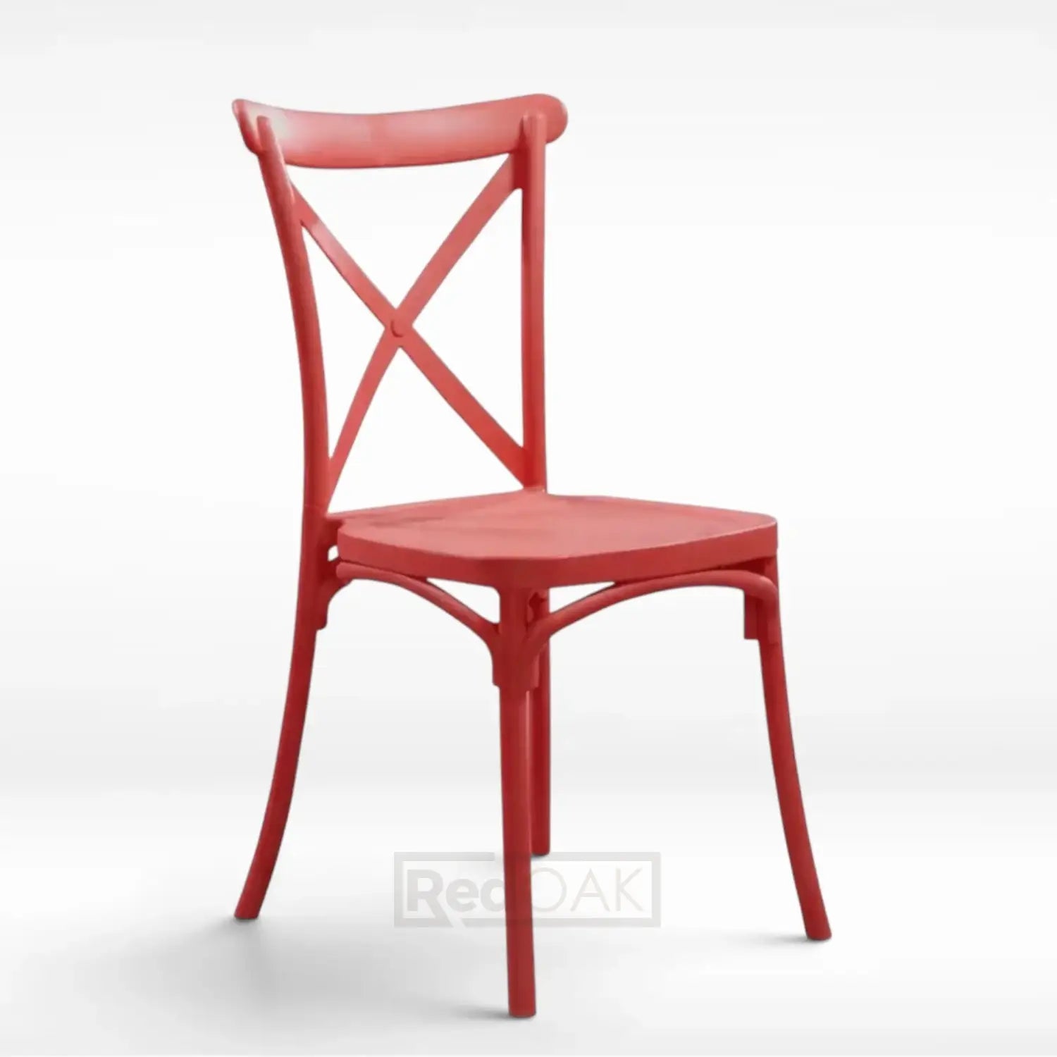 A red plastic dining chair with a curved backrest, crossed X-back design, and a square seat, shown on a light gray studio background.