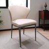 Beige chair in a room with a wooden cabinet and plant