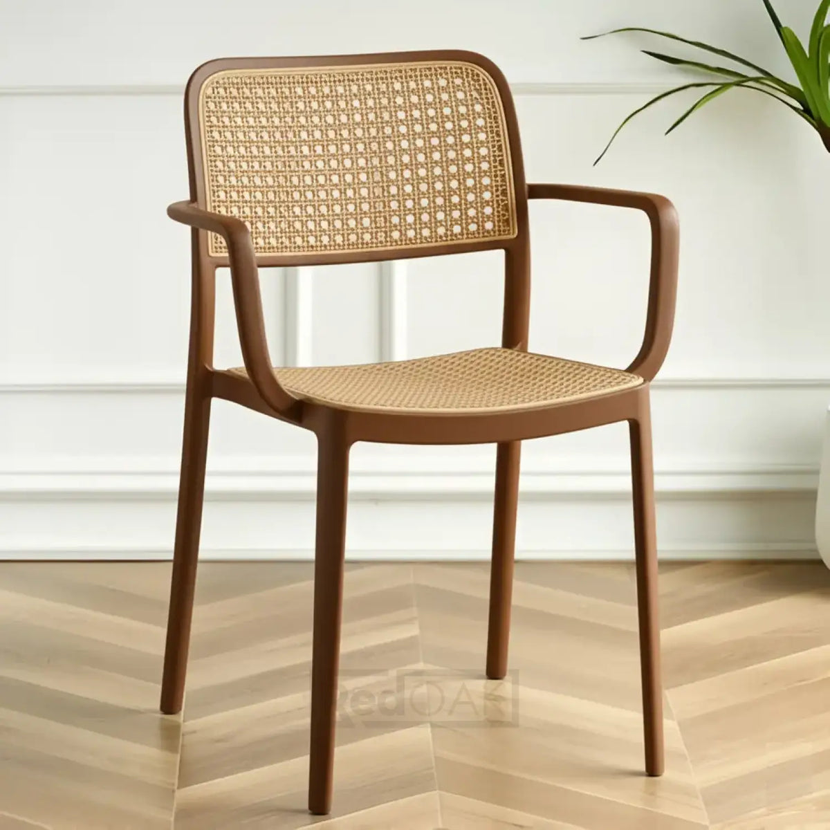 Brown wicker chair on a wooden floor with a white wall background