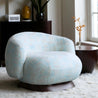 Light blue patterned armchair in a room with decor elements.