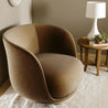 Brown armchair in a room with a side table and lamp.