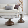 Two marble-top coffee tables with wooden bases in a living room setting.