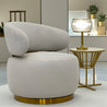 Modern beige armchair with gold base in a stylish room setting
