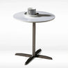 Small round table with a white top and chrome metal base on a white background