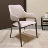 Modern chair with white cushioned seat and backrest on a textured floor.